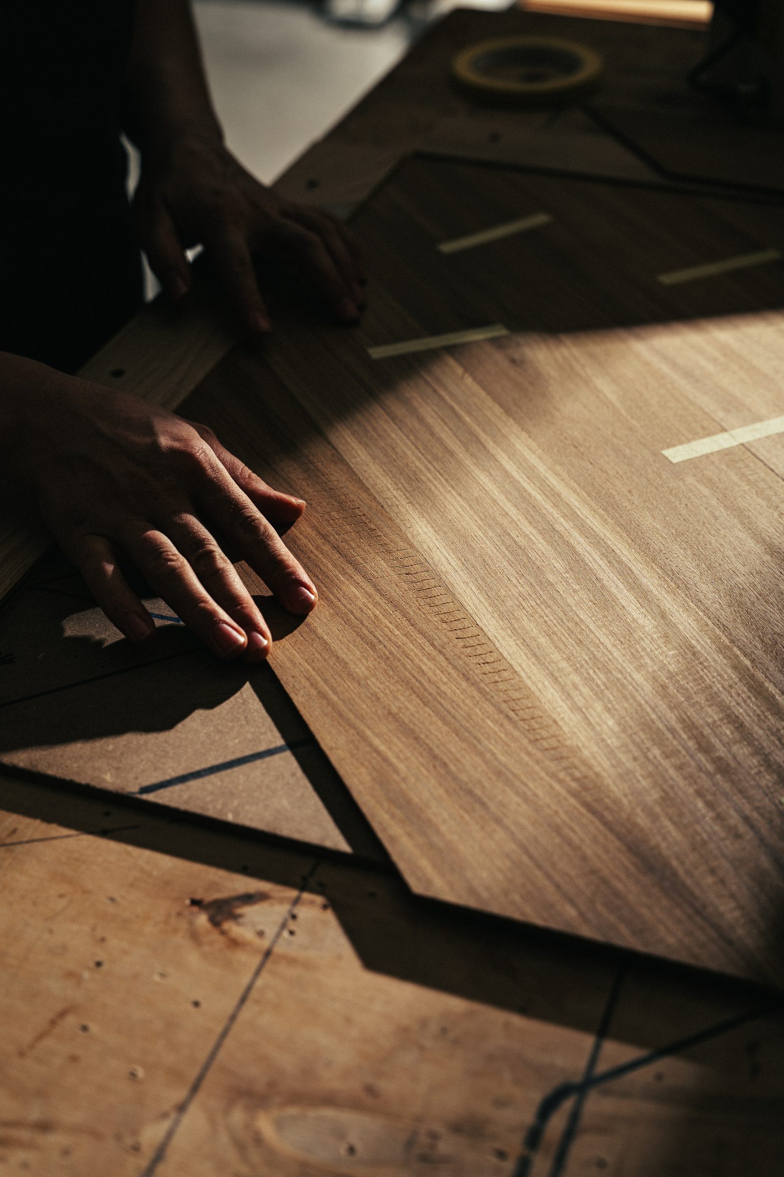 Mani dell'artigiano compongono un modulo di parquet a disegno